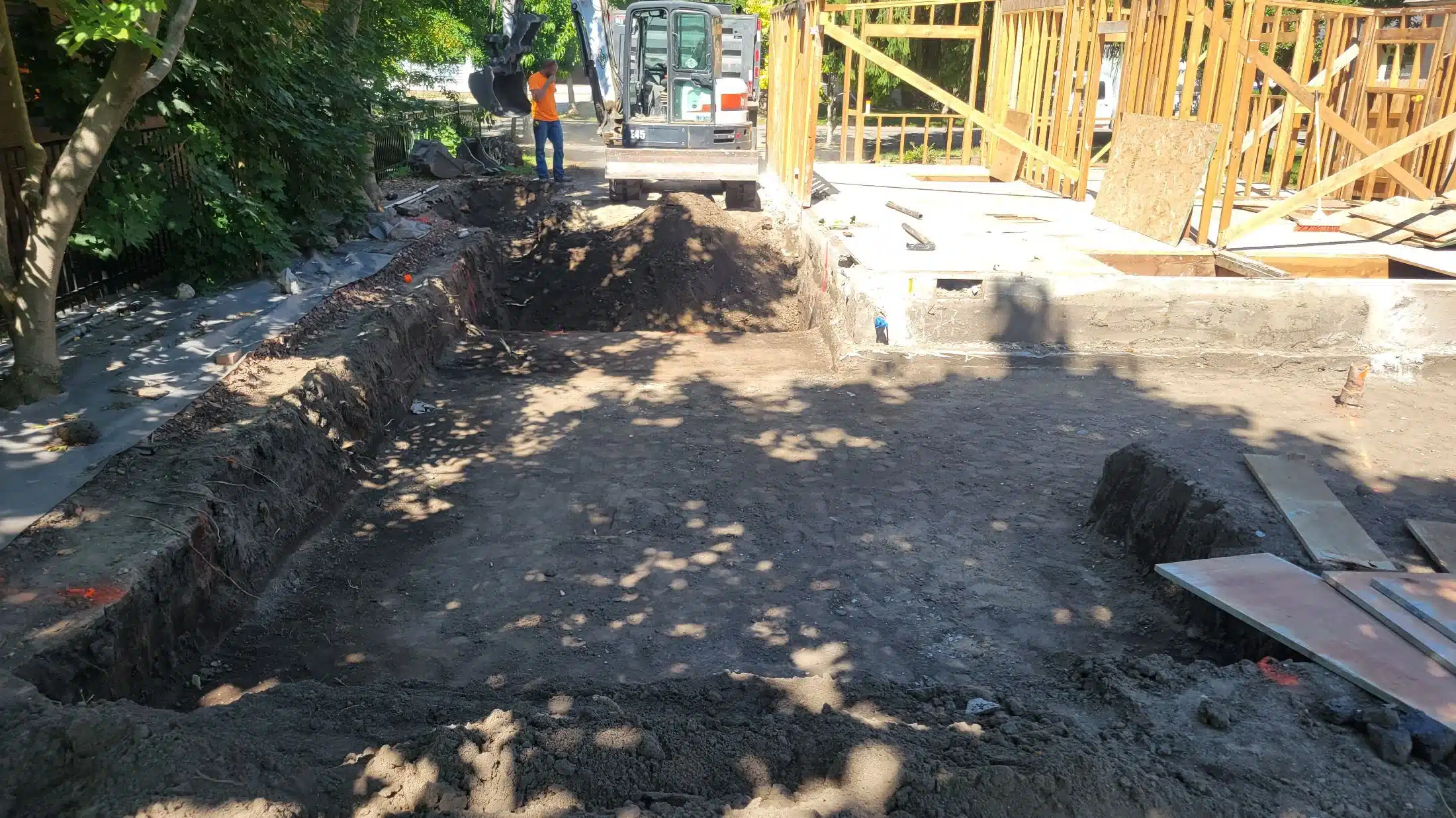 Excavator trenching for a French drain installation on a residential lot in Star, Idaho
