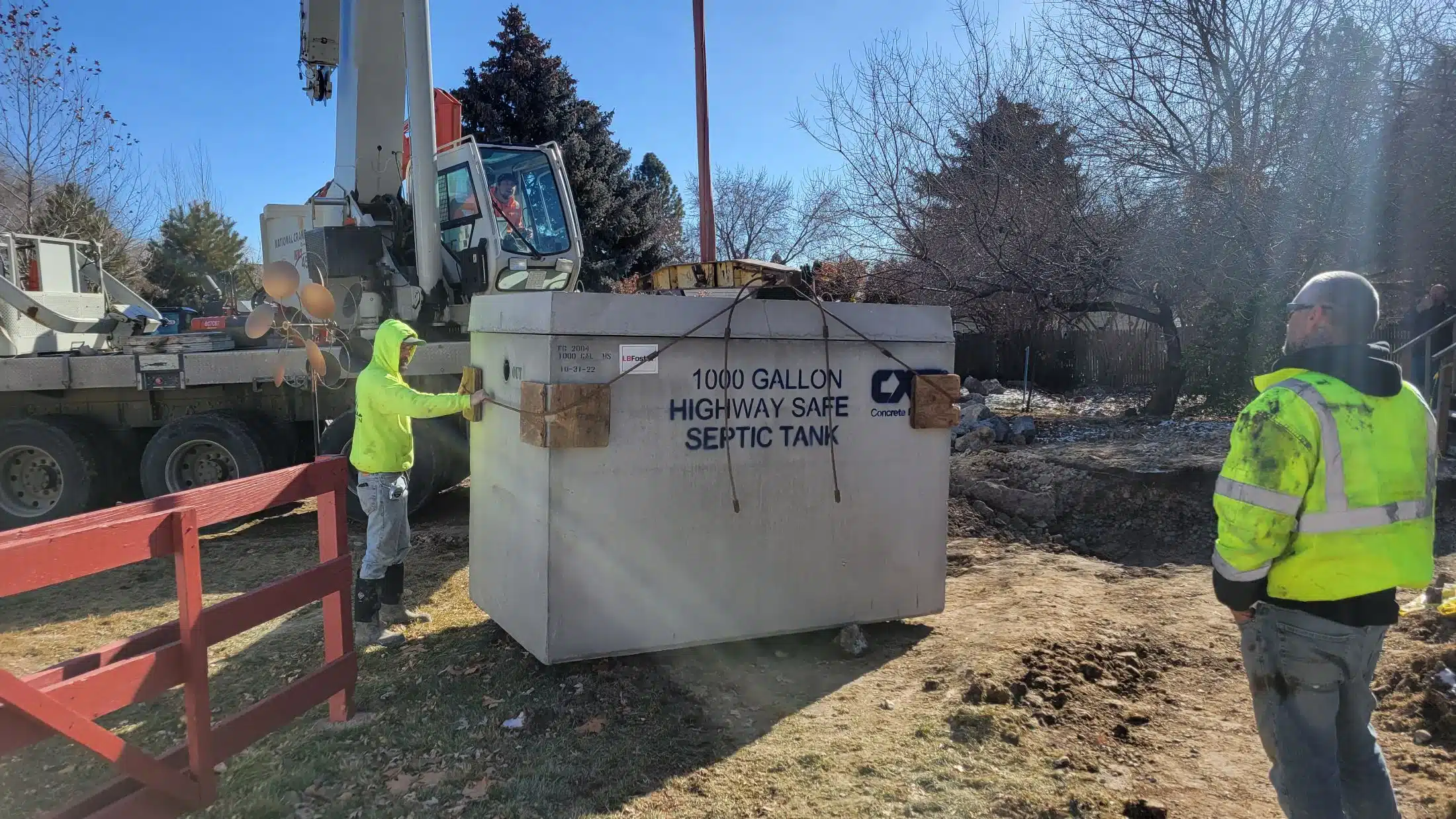 Excavator setting a septic tank during a system installation on acreage near Star, Idaho