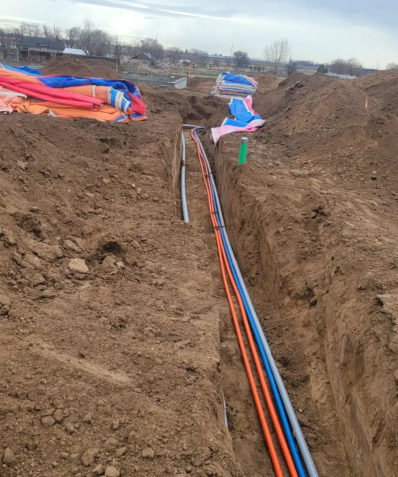 Crew placing pipe in an excavated utility trench in Idaho