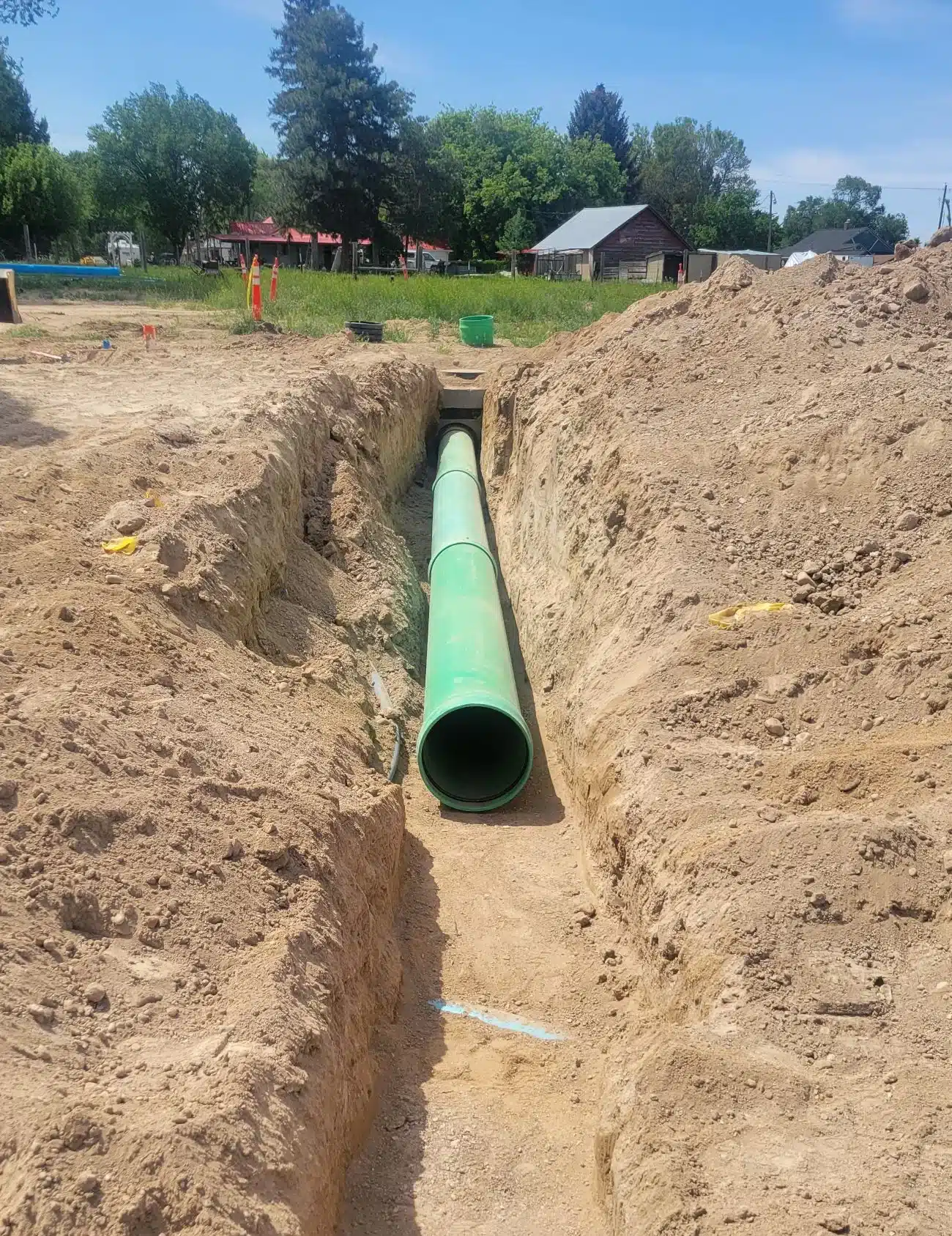 Excavator digging a sewer trench along a residential street in Eagle, Idaho
