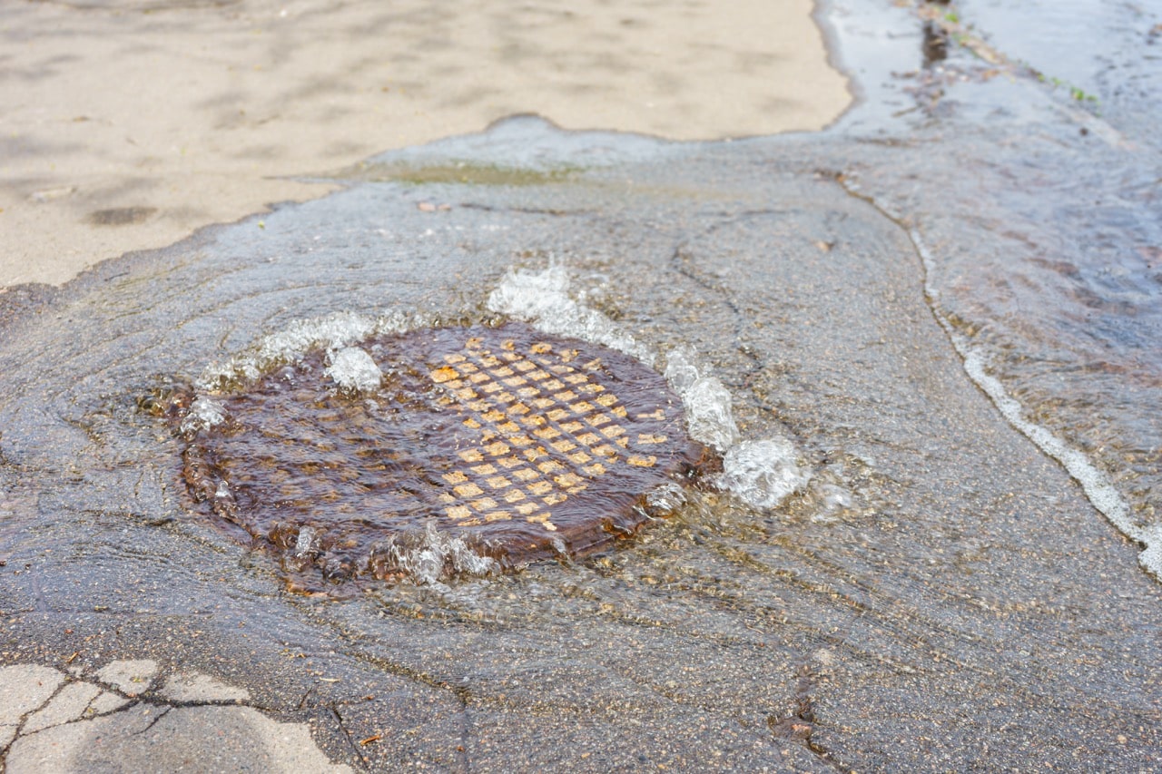Water pouring out of a sewer hatch during an underground line failure